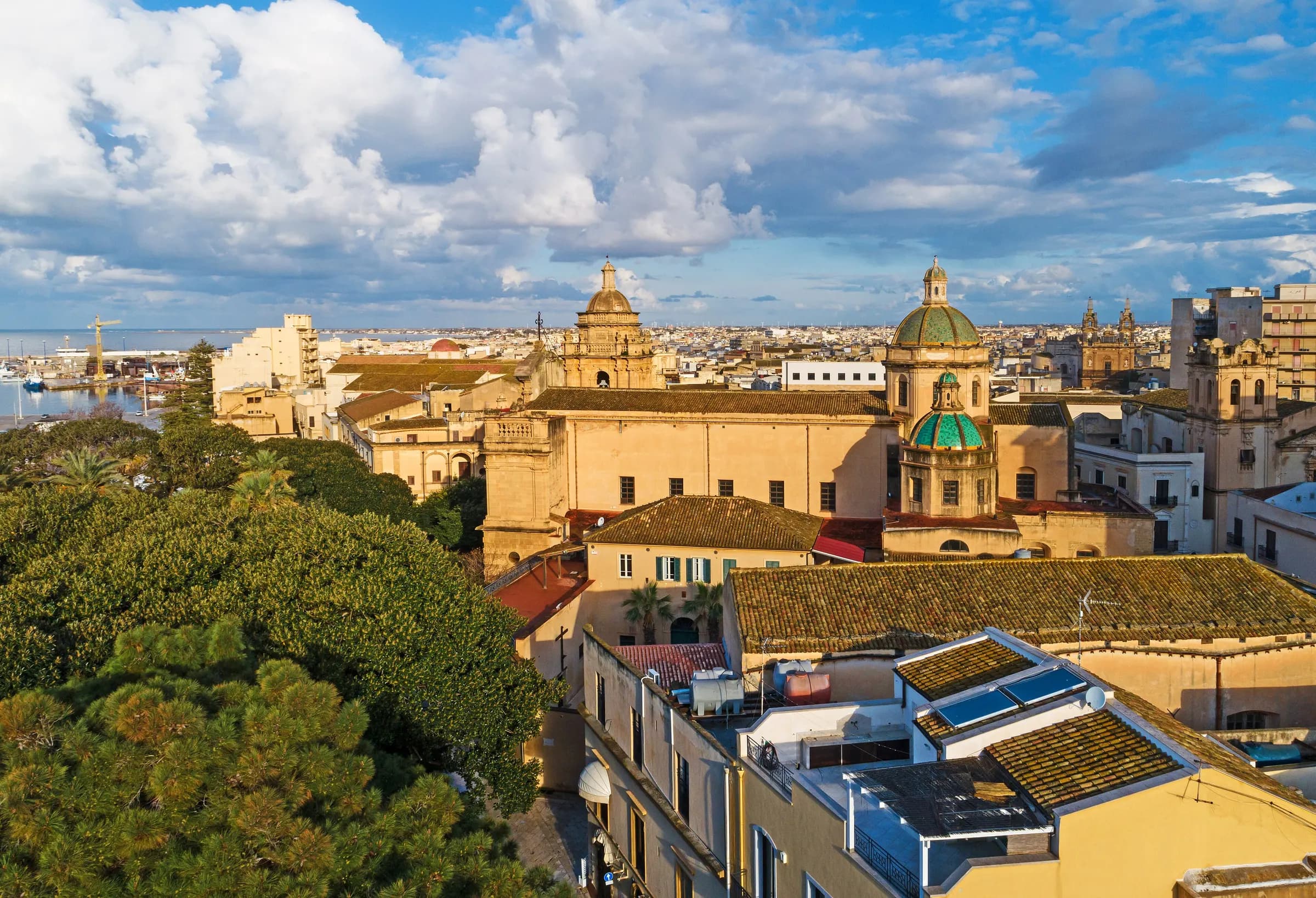 Mazara del Vallo from above, its domes and church towers rising over the rooftops with the harbour and the sea beyond