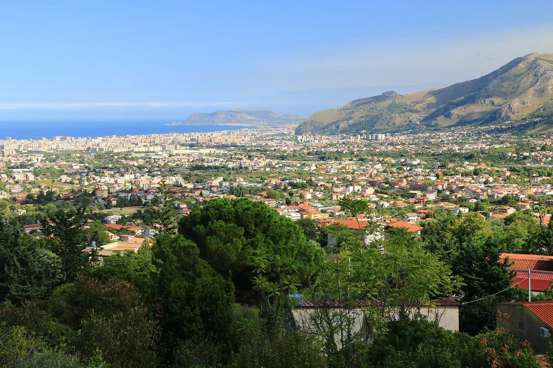 The view down from Monreale over the plain to Palermo, the city spread along the coast with mountains to the right and the sea beyond