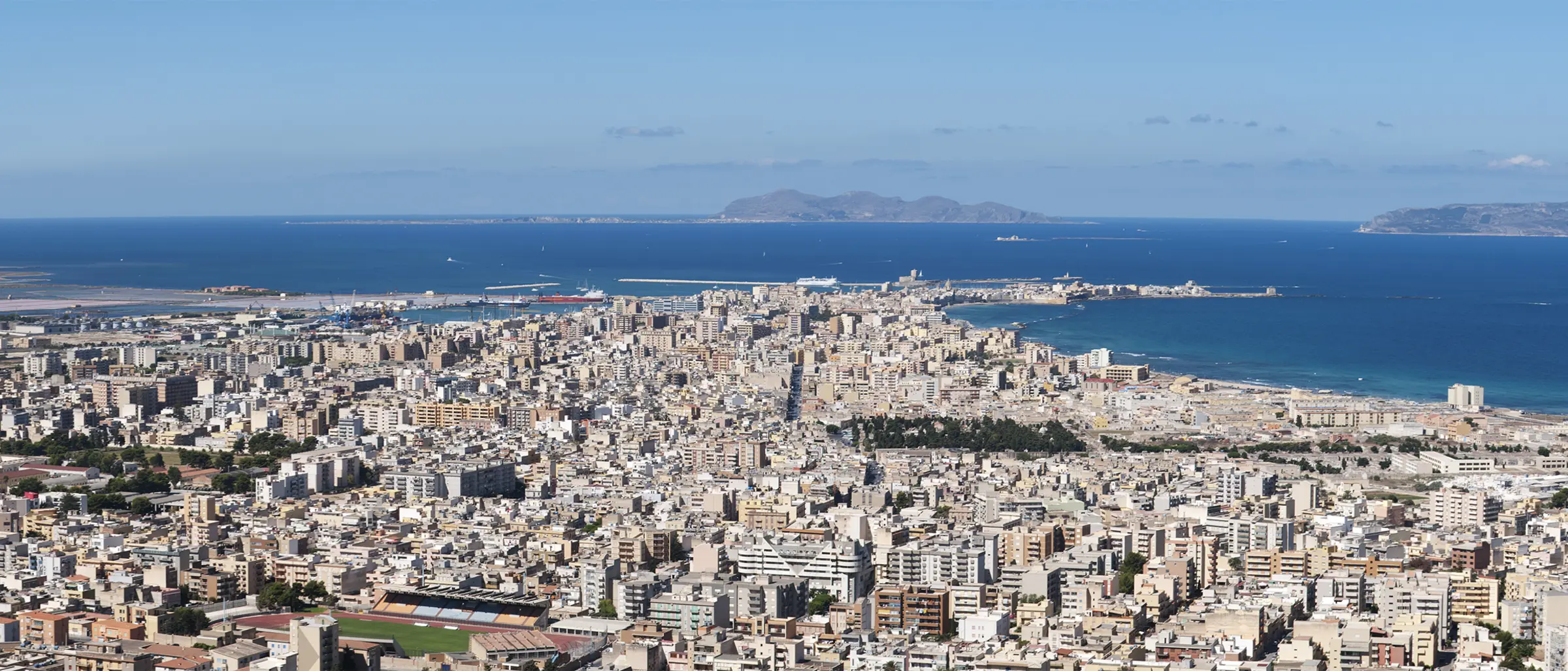 Trapani seen from above, the city spreading out to its port with the sea and the Egadi islands on the horizon